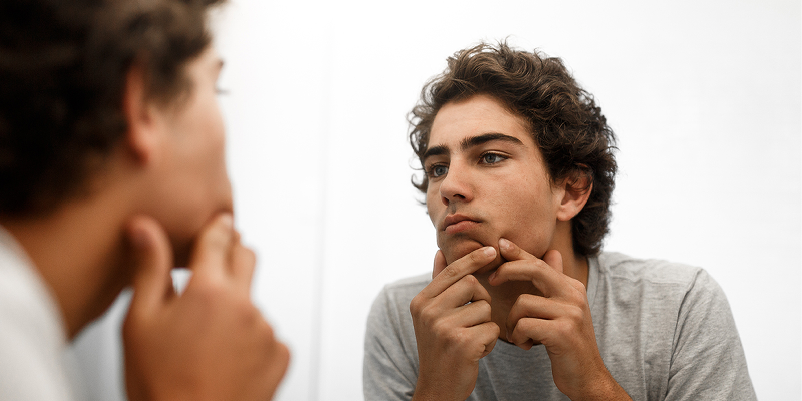 teenager with buttons in front of the mirror