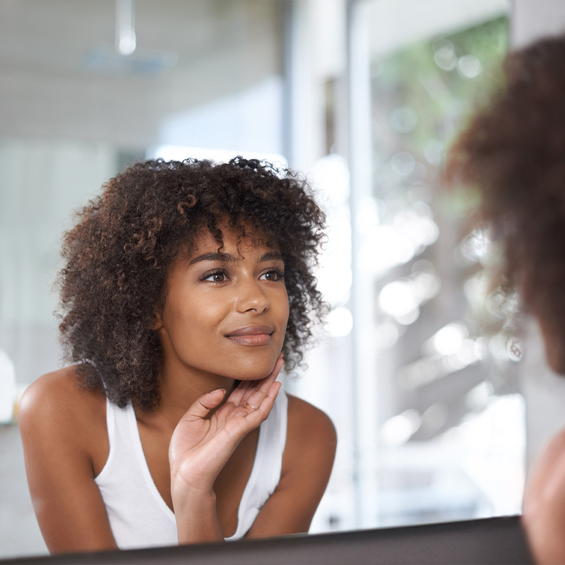 Woman in mirror with dark spots